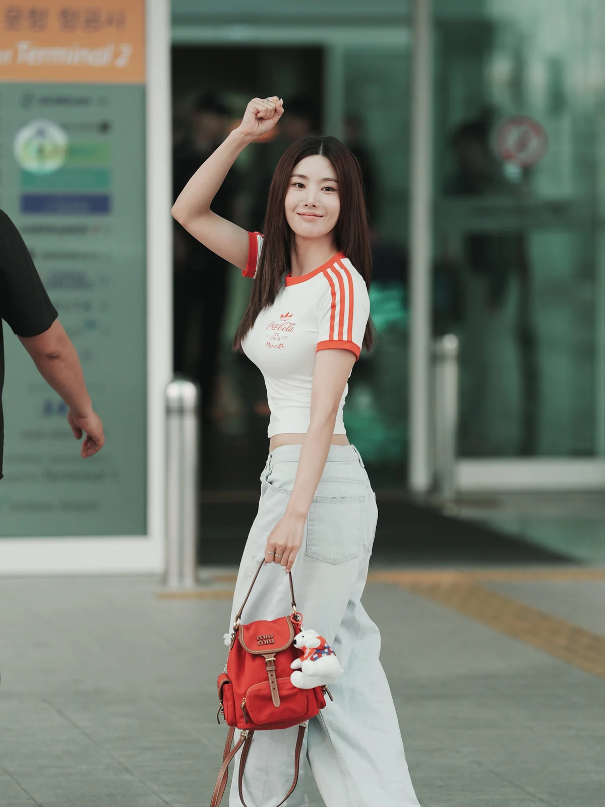 흰색 크롭 티와 연청 와이드 데님, 빨간 미우미우 백을 든 권은비의 공항 패션