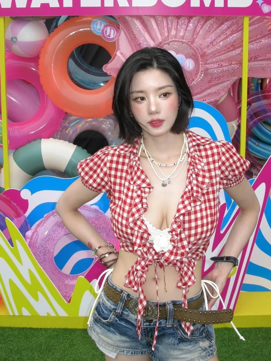 2025 워터밤 포토월 앞에서 빨간 체크 크롭 셔츠와 데님 쇼츠를 입은 권은비