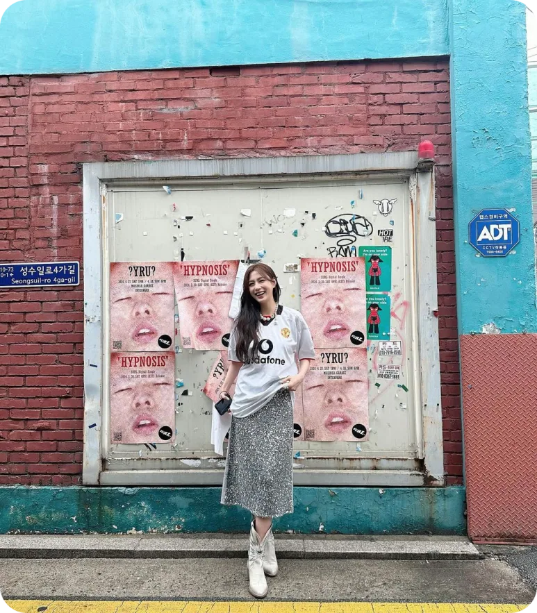 벽화 앞에서 화이트 맨유 유니폼과 스팽글 스커트를 입은 오하영 전신