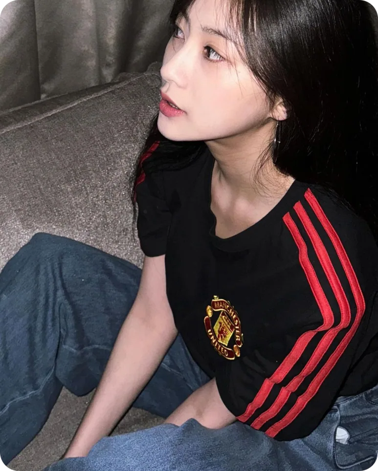 블랙 맨유 유니폼의 빨간 어깨선과 문장이 보이는 오하영