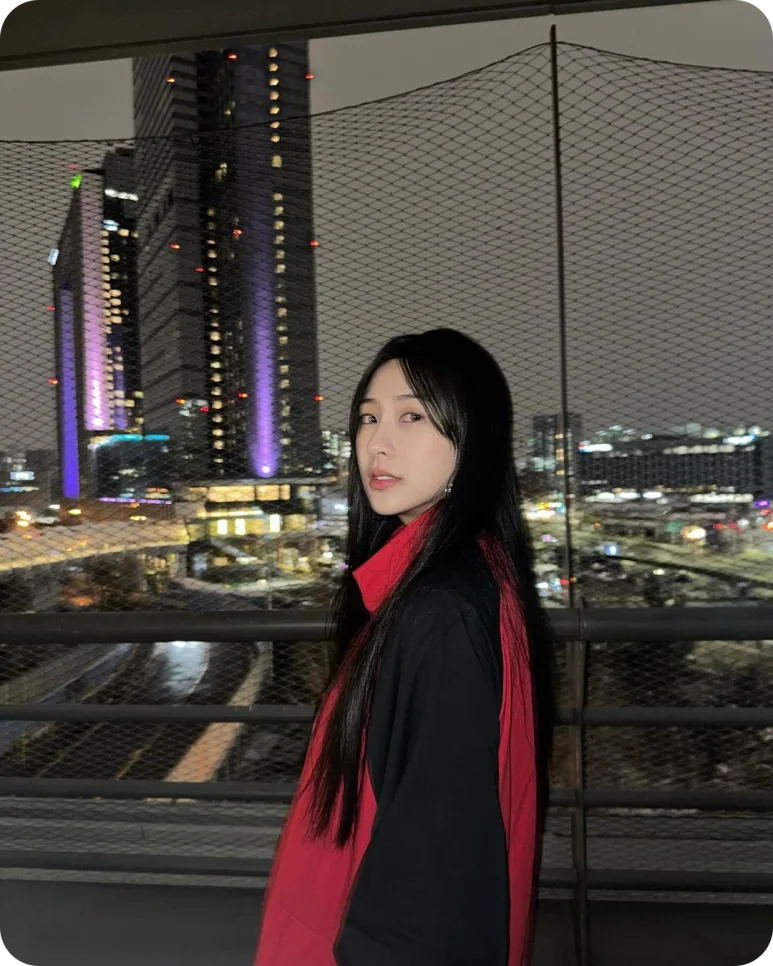 맨유 검정·빨강 셸 파카를 입은 오하영의 야간 측면 인물 사진