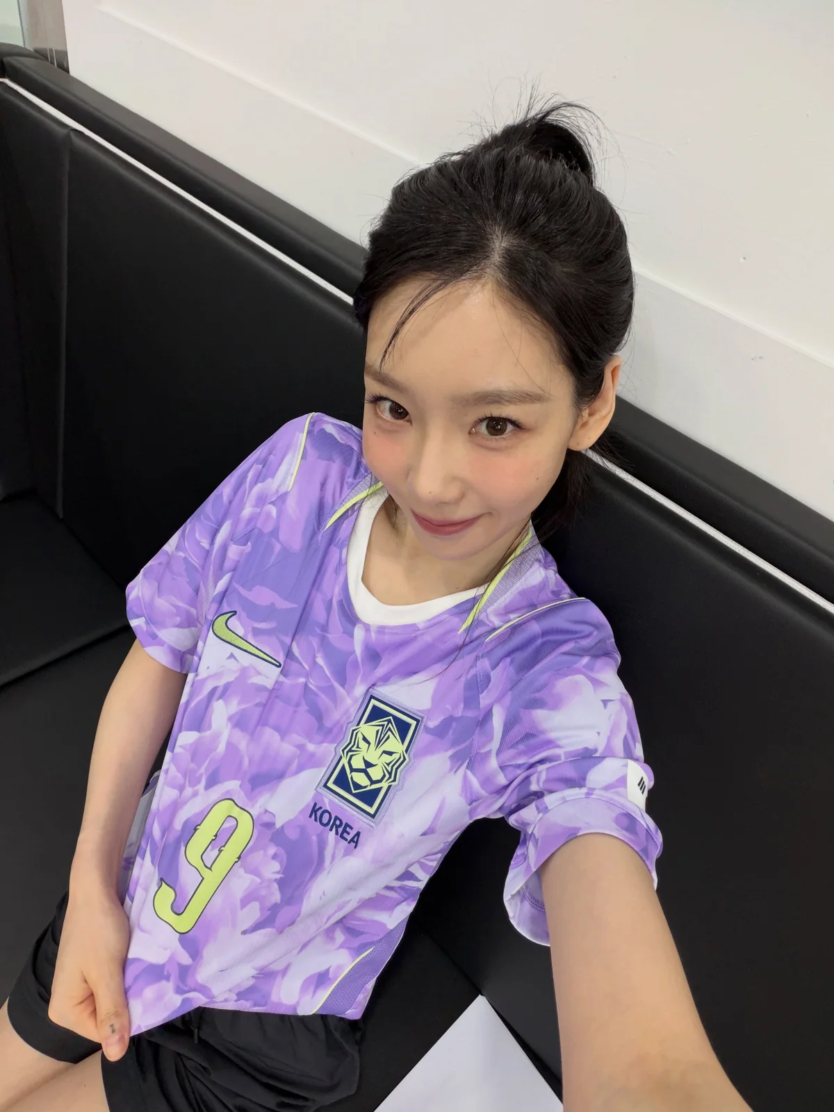 보라색 대한민국 어웨이 유니폼의 무궁화 패턴과 9번을 가까이 보여주는 태연의 셀피